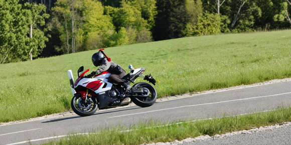 Motorcyclist wearing a helmet with a Hightail on it looking at the coast