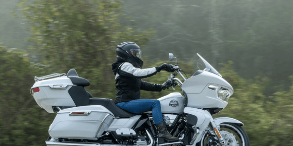 Motorcyclist wearing a helmet with a Hightail on it looking at the coast