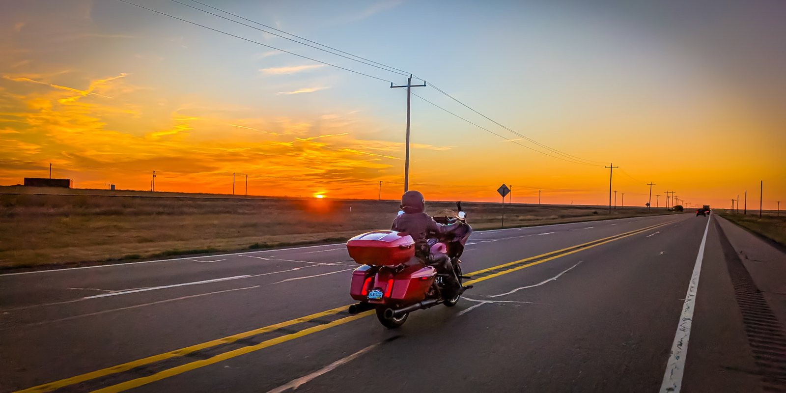 Motorcyclist wearing a helmet with a Hightail on it looking at the coast