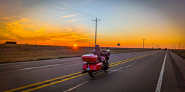 Motorcyclist wearing a helmet with a Hightail on it looking at the coast