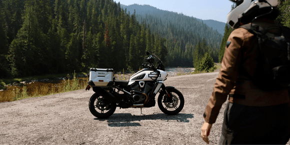 Motorcyclist wearing a helmet with a Hightail on it looking at the coast